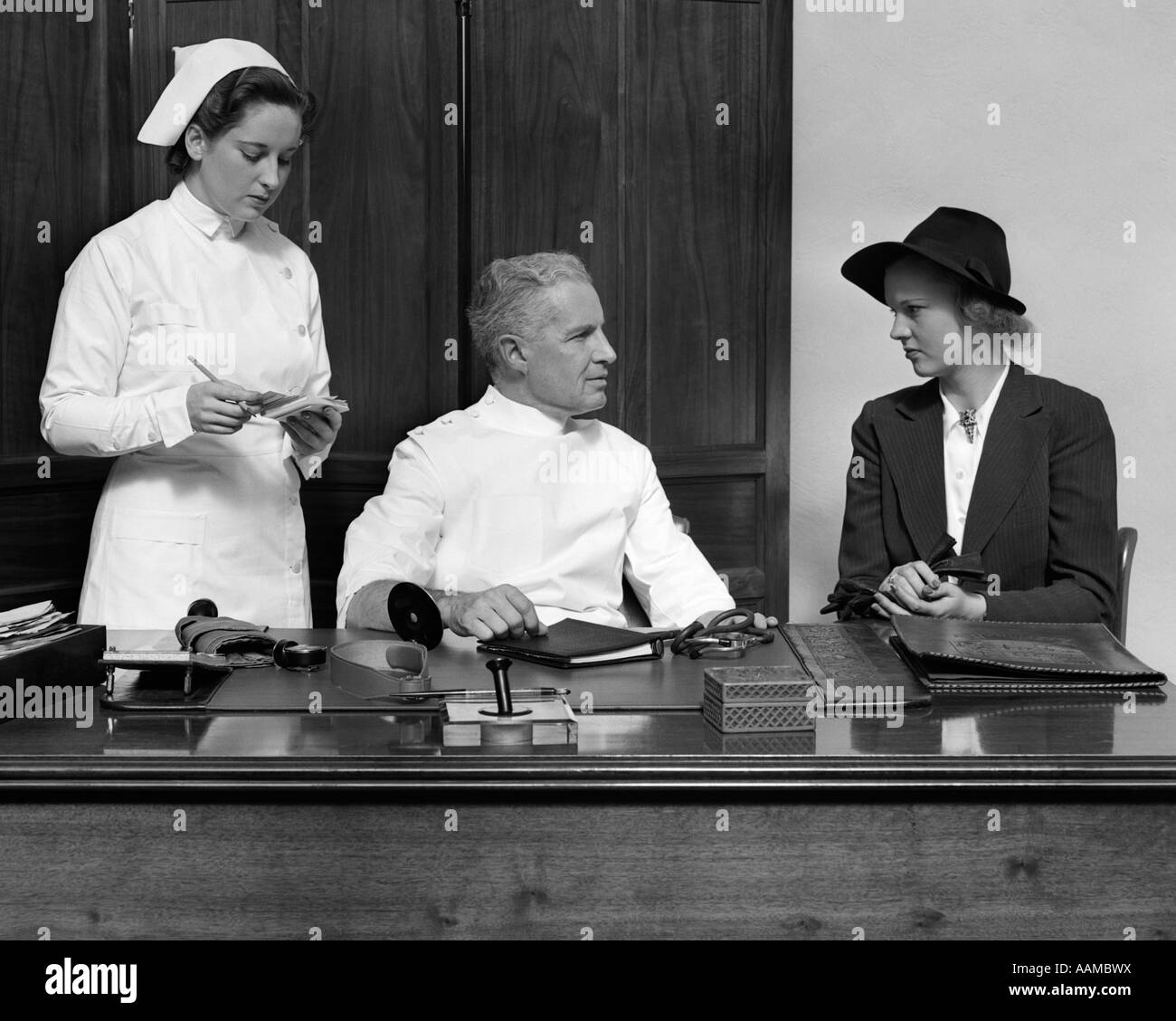 NURSE DOCTOR PATIENT CONSULTATION DESK RETRO 1940s 1950s Stock Photo