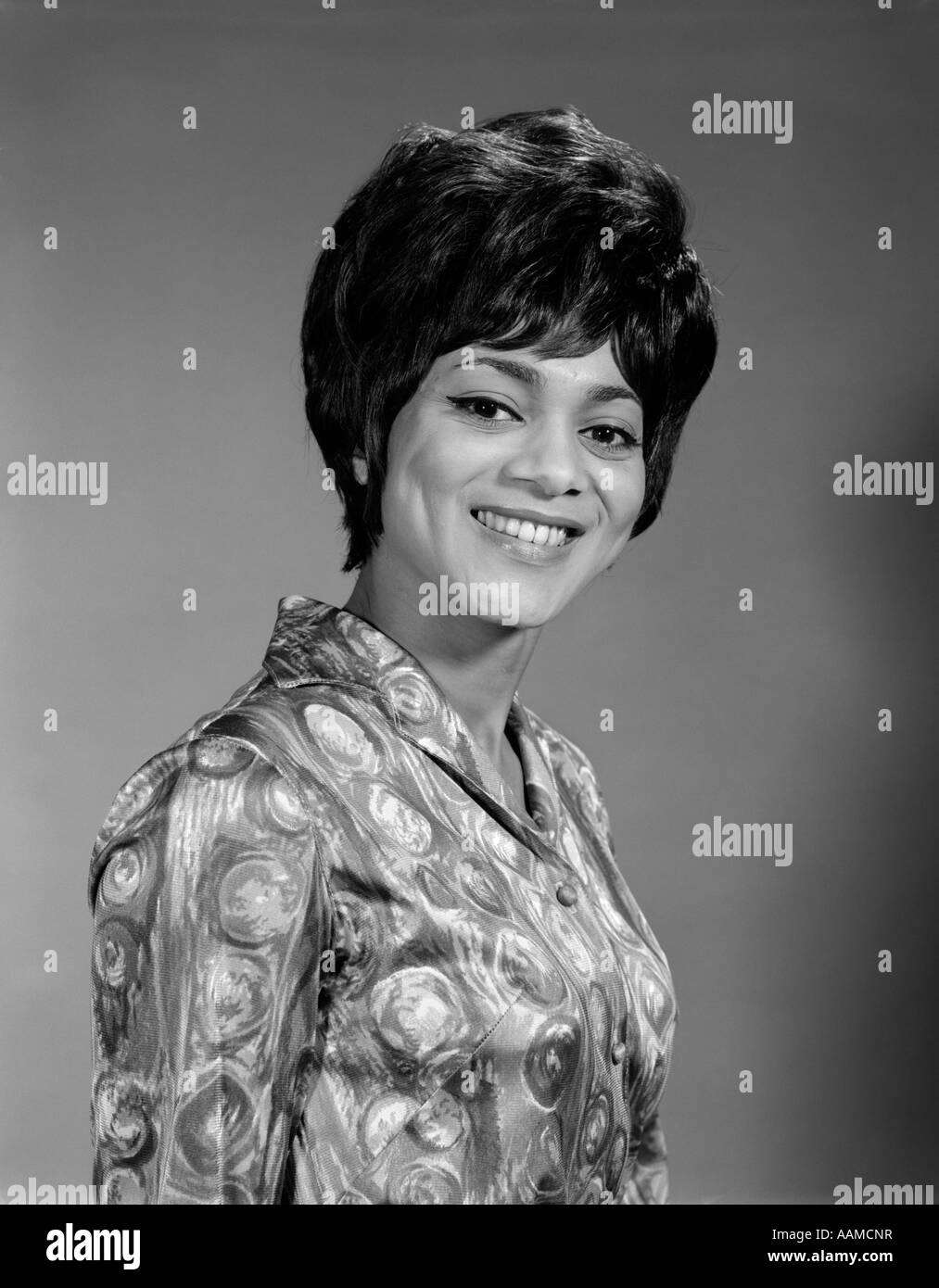 AFRICAN AMERICAN NEGRO BLACK WOMAN 3 4 POSE TOWARD CAMERA SMILE SHORT HAIR  TEETH BLOUSE LOUD BUSY DESIGN 1960s Stock Photo - Alamy