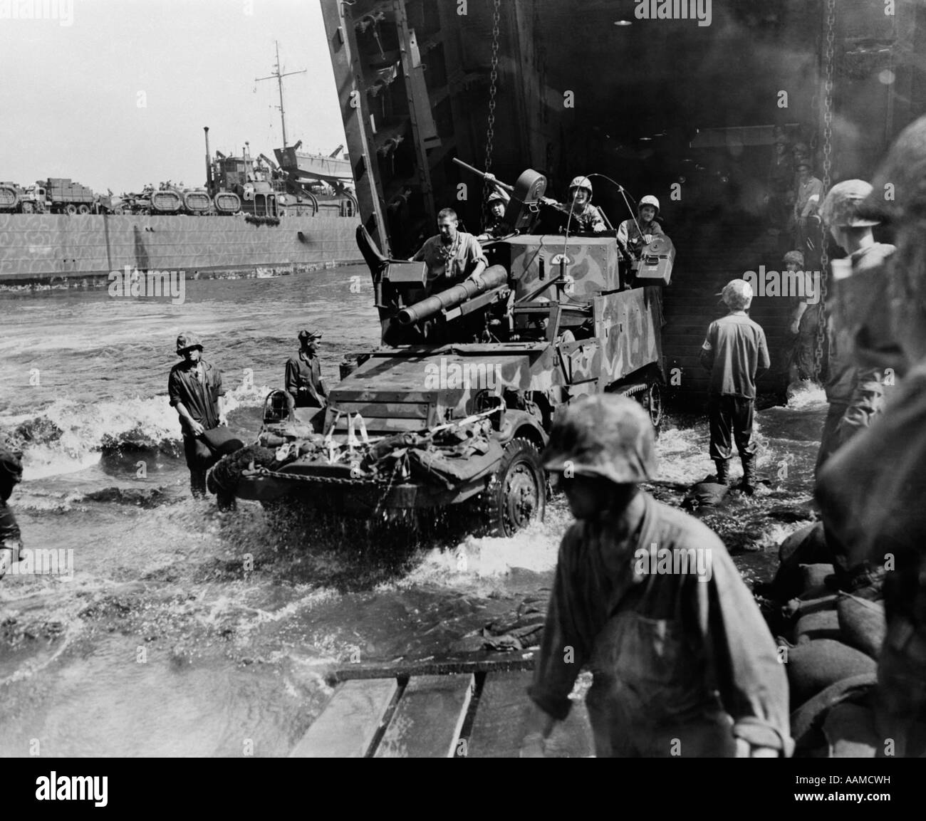 1940s MARINES EMERGE FROM NAVAL LANDING CRAFT ON A HALF TRACK VEHICLE ARMED WITH GUNS SOLDIERS WAR INVASION WEAPON MILITARY WWII Stock Photo