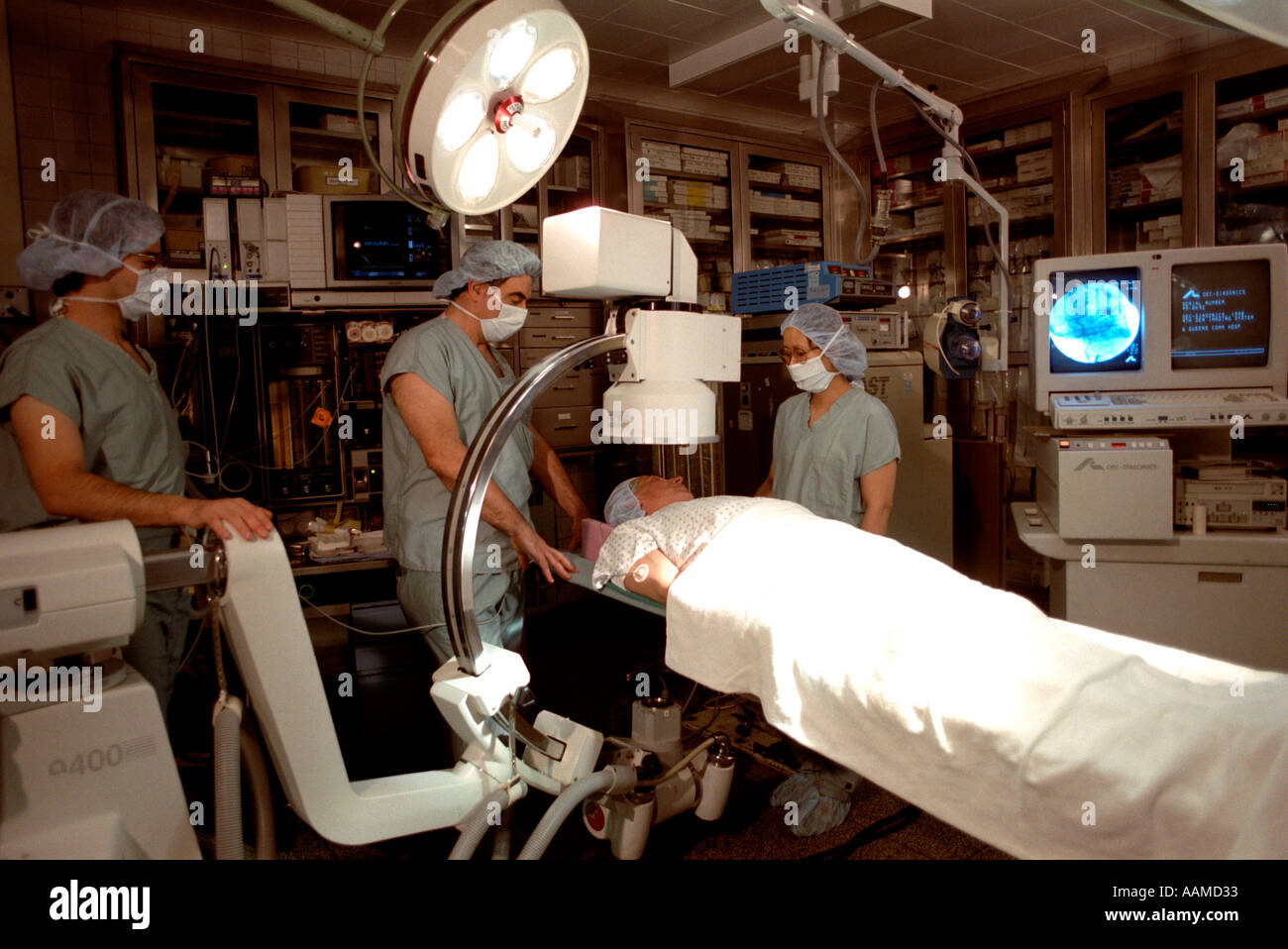 Three surgeons looking over a patient in an operating room in Beth Israel Hospital located in Queens New York Stock Photo