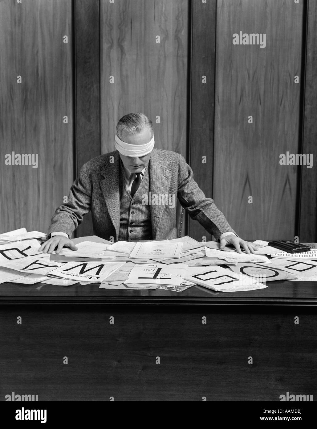 1940s BLINDFOLDED MAN IN OFFICE POST WAR SIGN ON DESK Stock Photo