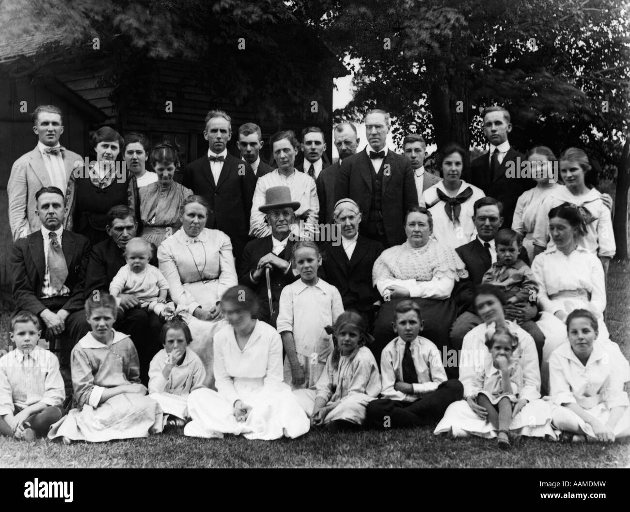 1910s GROUP PORTRAIT OF LARGE EXTENDED FAMILY OUTSIDE IN FRONT OF HOME