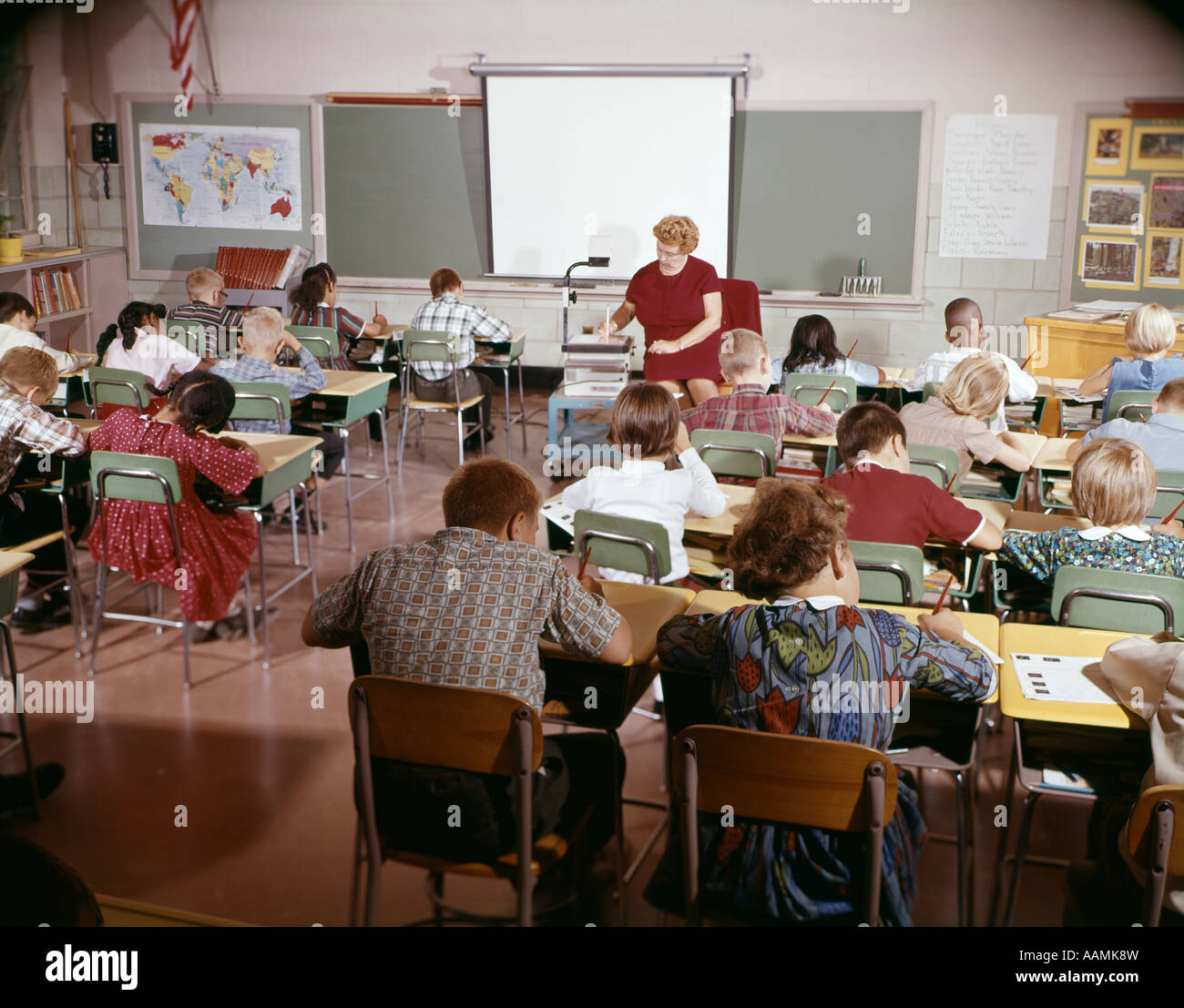 1960s TEACHER WITH CLASS IN SCHOOLROOM WITH AUDIO VISUAL MACHINE EQUIPMENT Stock Photo