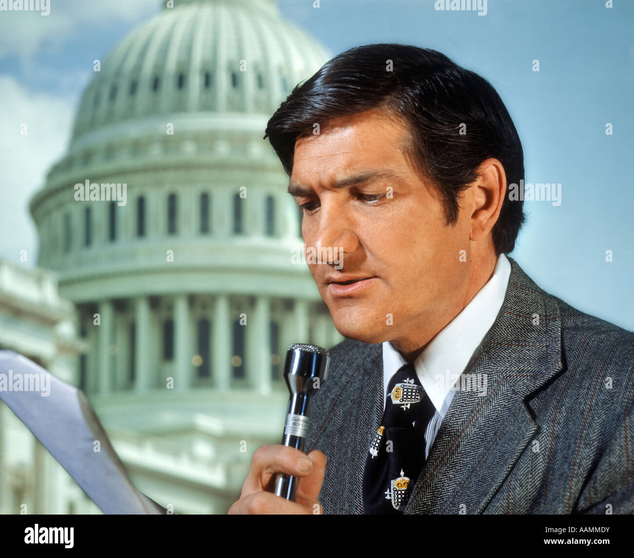 1970s NEWSMAN REPORTER READING SCRIPT INTO MICROPHONE IN FRONT OF WASHINGTON DC CAPITOL DOME Stock Photo
