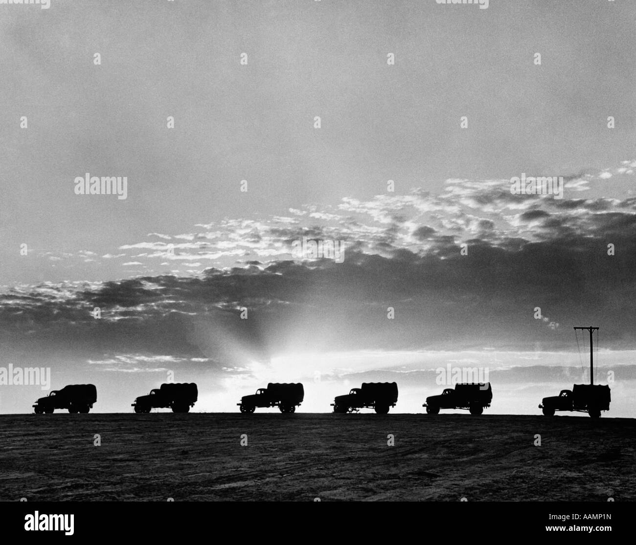 1940s LINE OF MILITARY TRUCKS AT SUNSET Stock Photo