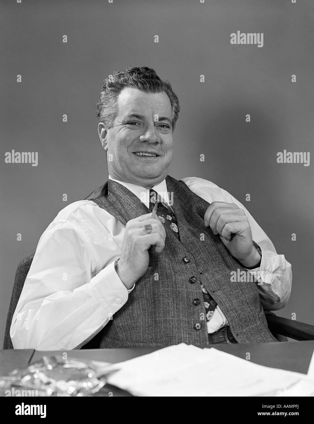 1940s MAN IN SUIT SITTING AT DESK SMILING Stock Photo