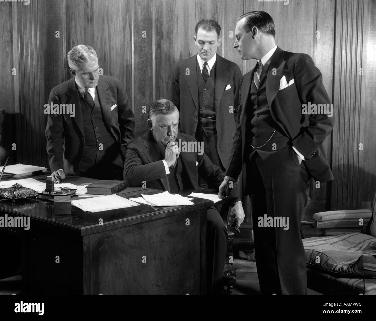 1930s FOUR BUSINESSMEN CONFERENCE OFFICE SERIOUS EXPRESSIONS Stock Photo