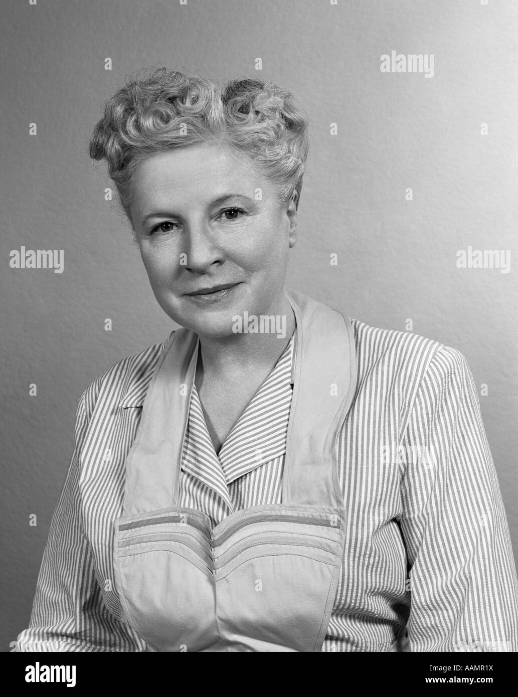 1950s PORTRAIT OF MATURE WOMAN MOTHER GRANDMOTHER WEARING APRON PINSTRIPE BLOUSE Stock Photo