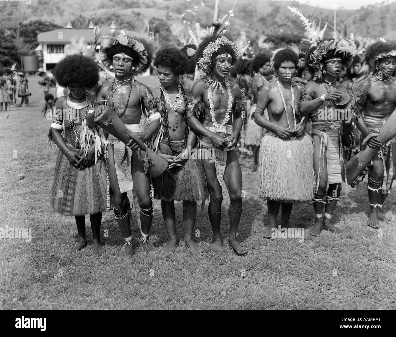 1920s 1930s GROUP OF NATIVE PAPUAN DANCERS IN COSTUME GRASS SKIRT MUSIC FOLK DANCE PORT MORESBY NEW GUINEA Stock Photo