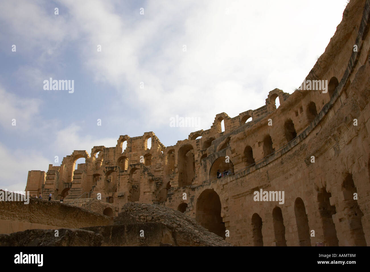 upper tiers of the old roman colloseum from the inside looking up at blue cloudy sky at el jem tunisia Stock Photo