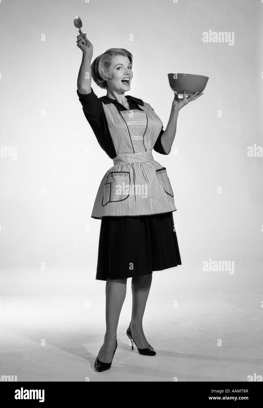 1950s WOMAN HOUSEWIFE IN KITCHEN APRON MIXING BAKING INGREDIENTS IN BOWL  Stock Photo - Alamy