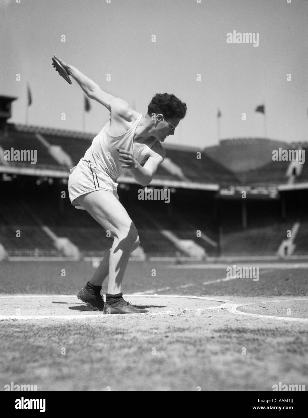 1930s BOY TRACK AND FIELD ATHLETE GETTING READY TO THROW A DISCUS Stock