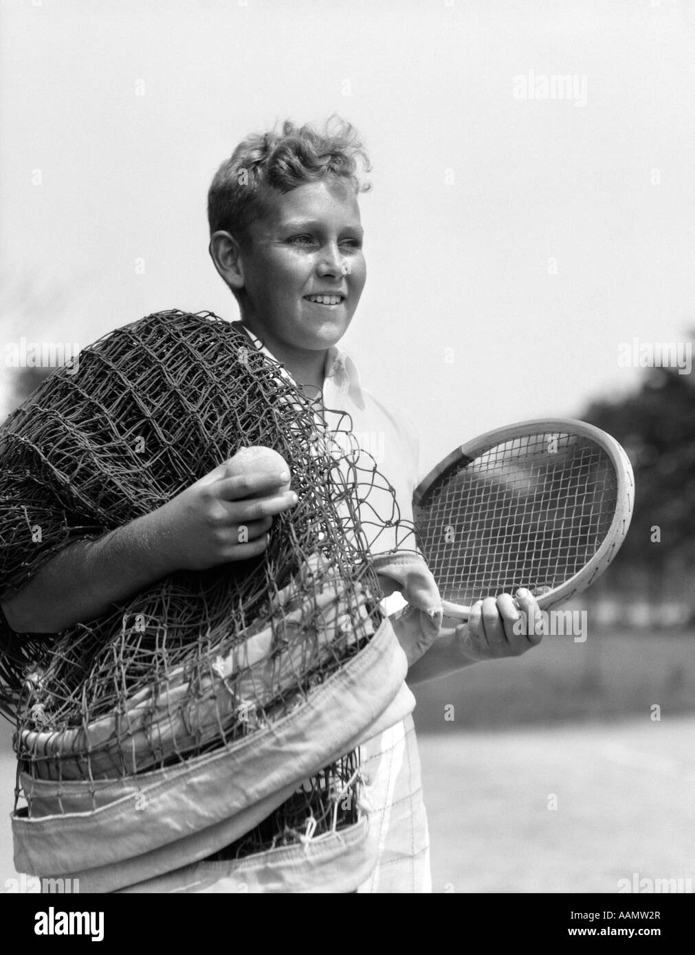 1920s 1930s BOY TENNIS PLAYER HOLDING RACKET NET AND BALL Stock Photo