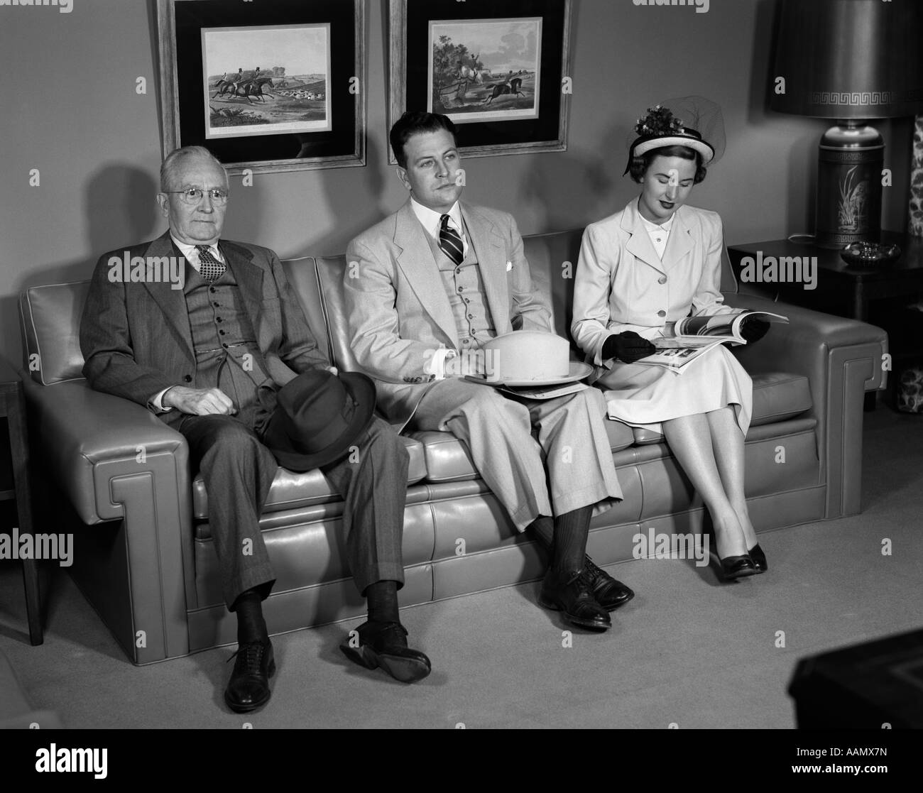 1950s MEN WOMAN SOFA COUCH SITTING HATS WAITING ROOM SUIT Stock Photo