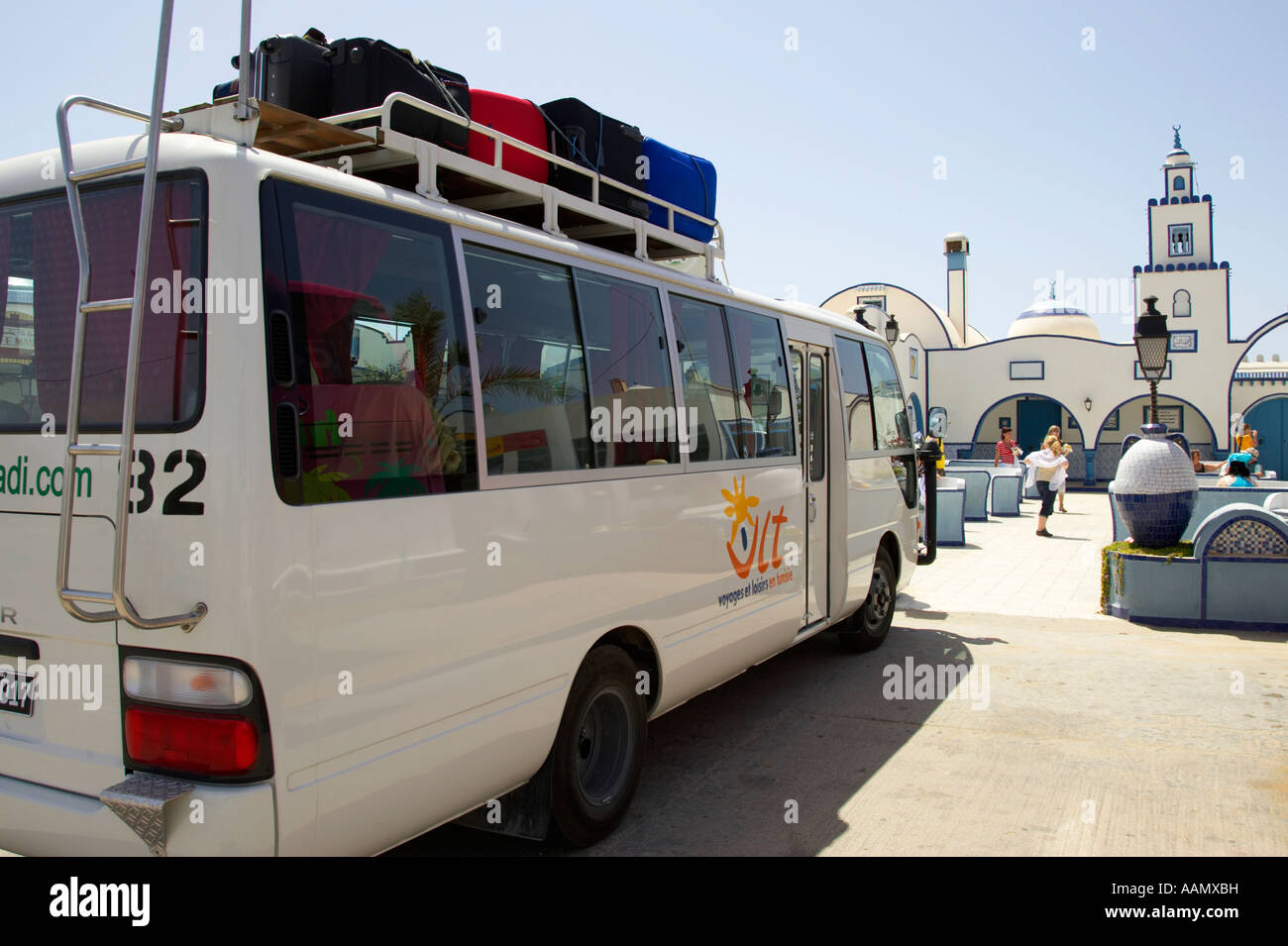 tourist bus with luggage on roof stopped outside a cafe and rest stop by the side of the highway in Tunisia Stock Photo