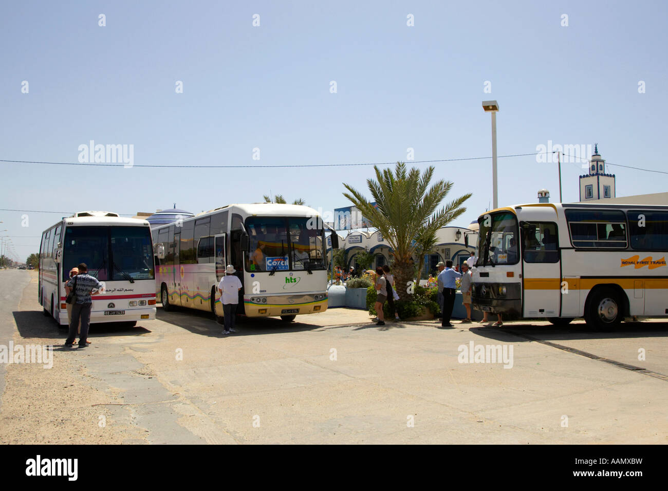 tourists get back on three tour busses parked after rest stop at the side of the highway in tunisia Stock Photo