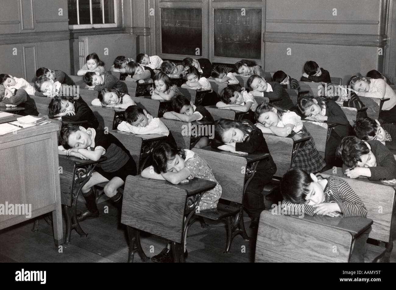 1930s ELEMENTARY GRADE SCHOOL STUDENTS CHILDREN SLEEPING WITH HEADS RESTING ON THEIR DESKS Stock Photo