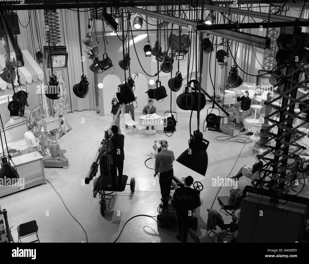 1960s BEHIND-THE-SCENES FILMING OF TV TALK SHOW IN STUDIO WITH SEVERAL LIGHT FIXTURES AND MONITORS HANGING FROM CEILING Stock Photo