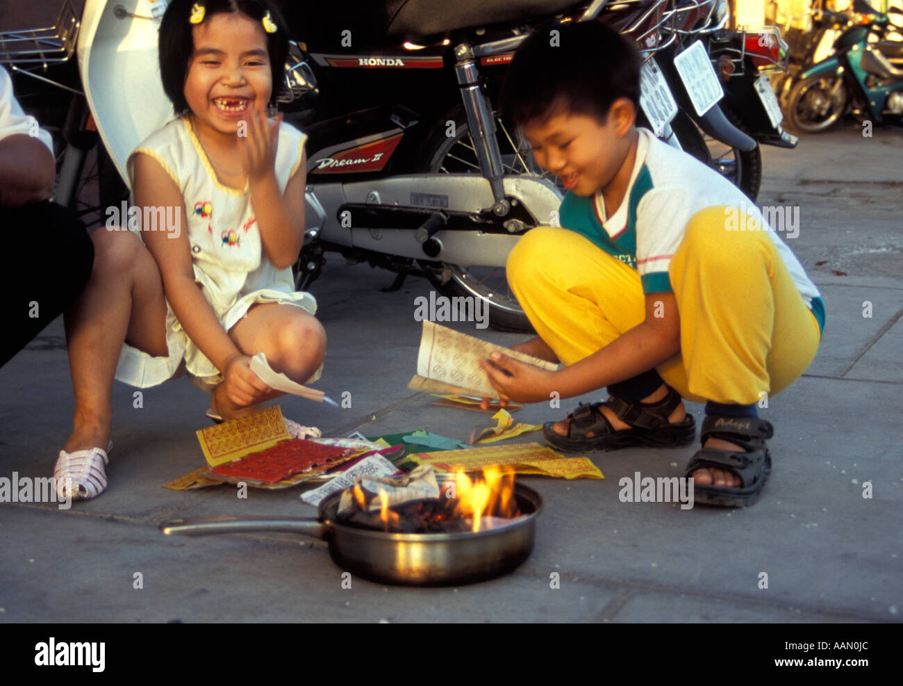 Children burning money in street, Nha Trang, Vietnam Stock Photo