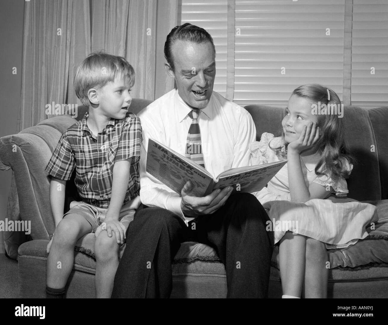 1950s FATHER WEARING DRESS SHIRT SLACKS TIE READING TO SON AND DAUGHTER ...