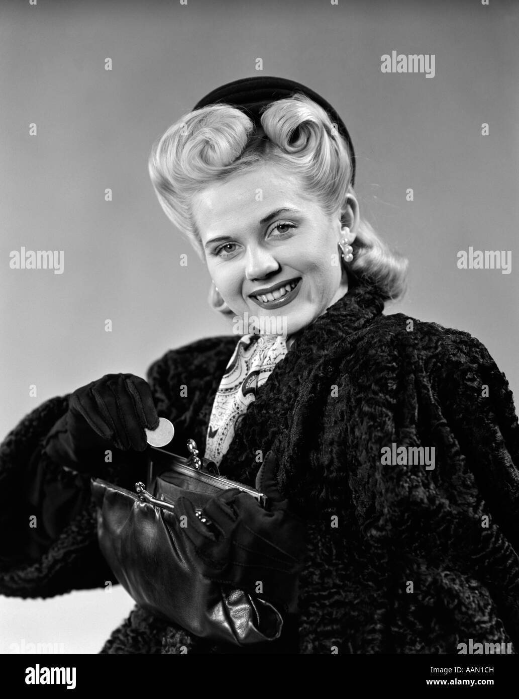 1940s DRESSED UP WOMAN SMILING PUTTING CHANGE IN PURSE Stock Photo