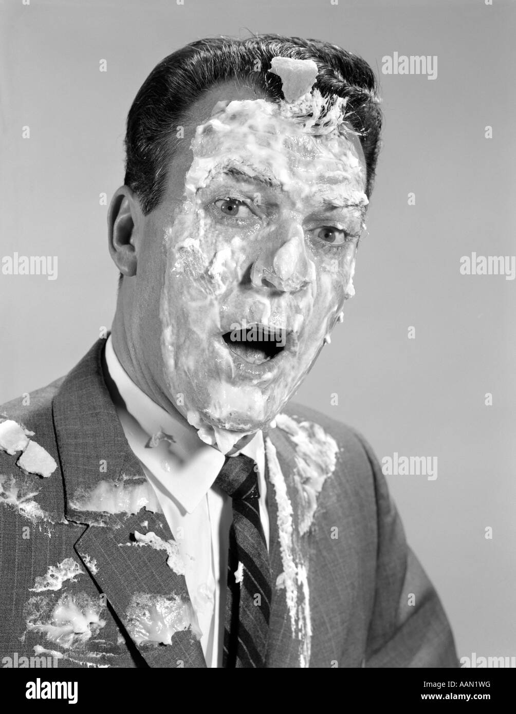 1960s MAN FACE SHOULDERS PIE IN THE FACE COVERED WITH MERINGUE SHAVING CREAM Stock Photo