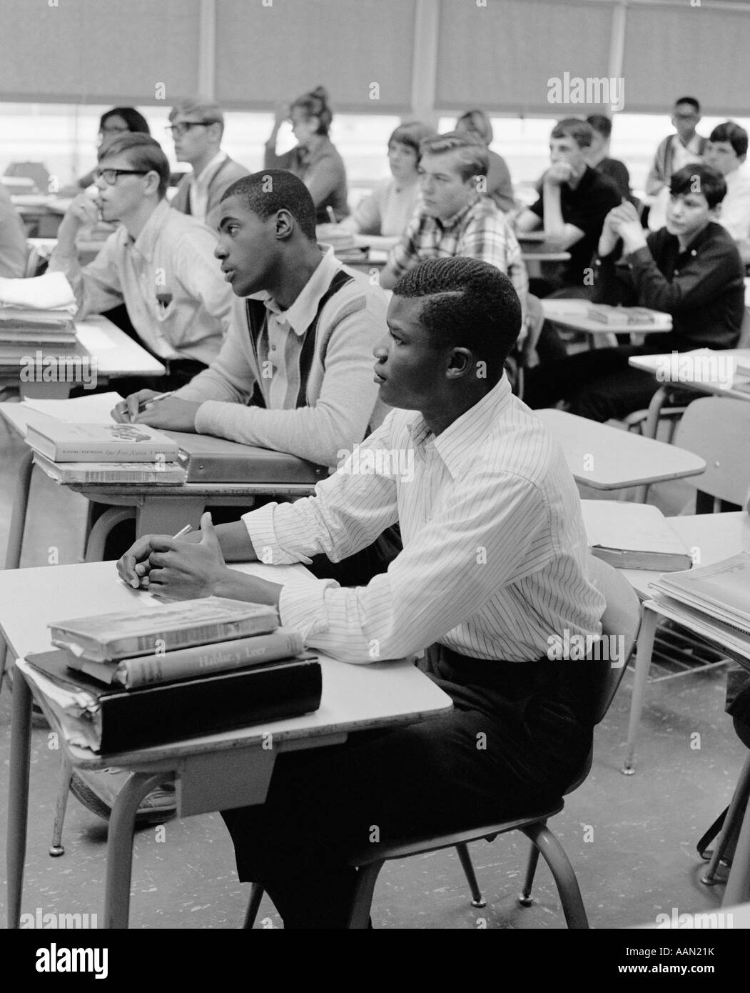 1960s TEEN BOYS GIRLS RACIAL ETHNIC MIX STUDENTS SIT AT DESKS HIGH SCHOOL CLASSROOM STUDY LEARNING EDUCATION EQUAL OPPORTUNITY Stock Photo