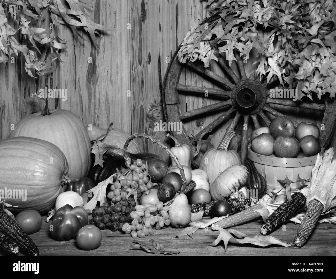 1970s STILL LIFE OF FALL HARVEST FRUITS & VEGETABLES SET UP IN FRONT OF WAGON WHEEL Stock Photo