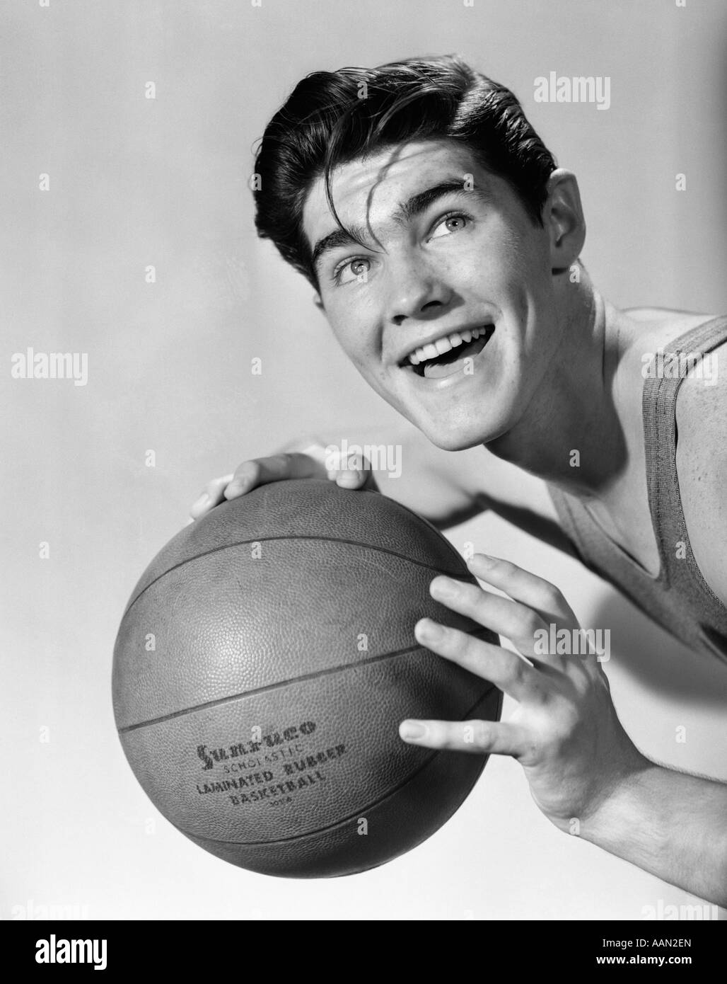 1950s BOY POSING HOLDING BASKETBALL SMILING Stock Photo