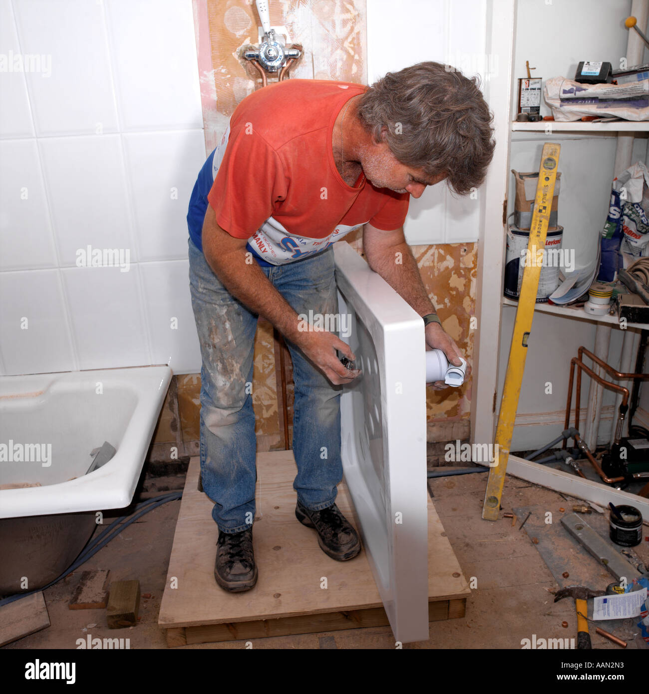 Plumber Fixing Waste in Shower Tray in New Bathroom Stock Photo Alamy