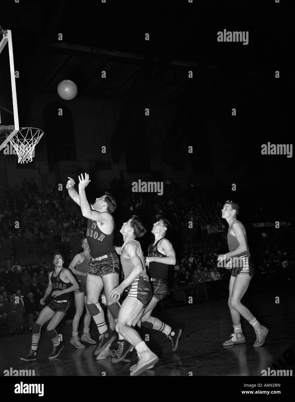 1940s 1950s BASKETBALL GAME INDOORS BASKETBALL JUST THROWN ABOUT TO GO IN BASKET Stock Photo