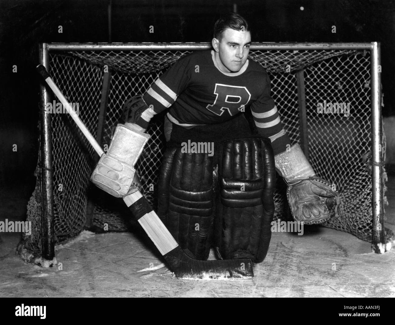 1940s SERIOUS ICE HOCKEY GOALIE STANDING IN FRONT OF THE NET WITH
