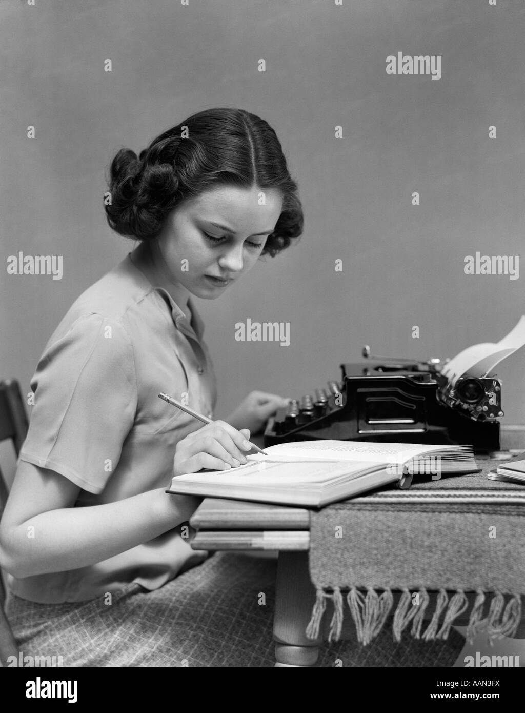 1930s YOUNG WOMAN STUDENT SITTING AT TABLE WITH TYPEWRITER AND BOOK ...