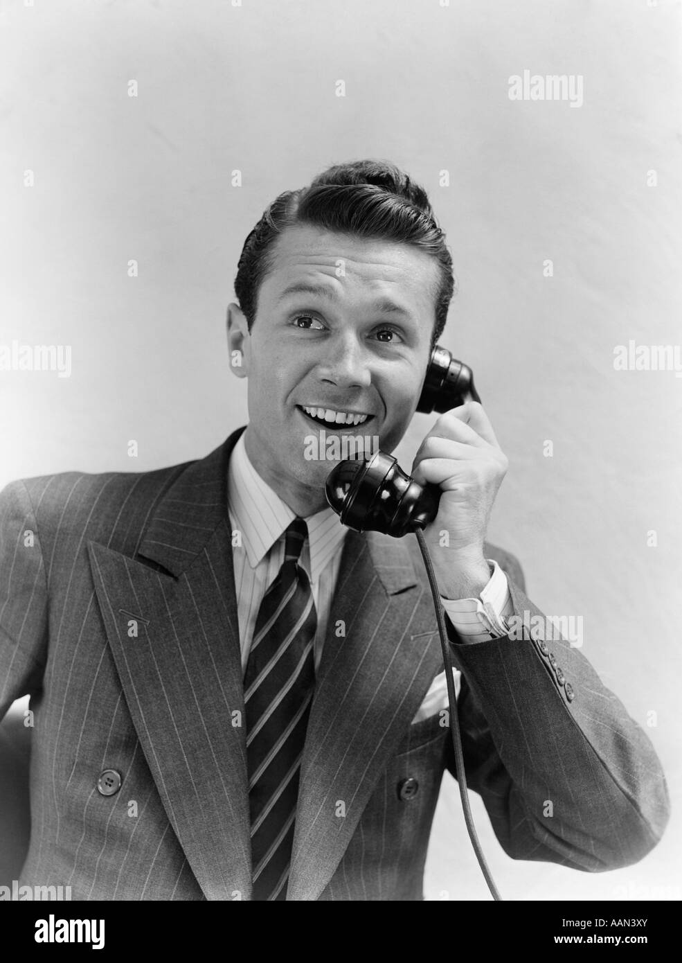 1930s MAN IN SUIT TALKING ON TELEPHONE Stock Photo
