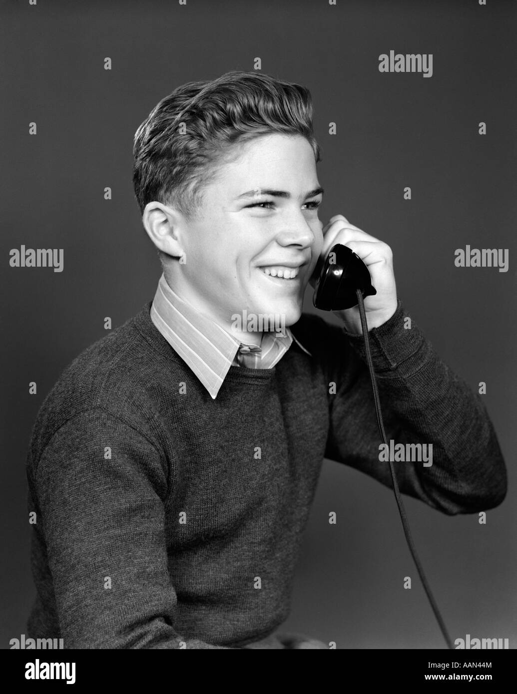 1940s YOUNG BOY TALKING ON TELEPHONE SMILING Stock Photo