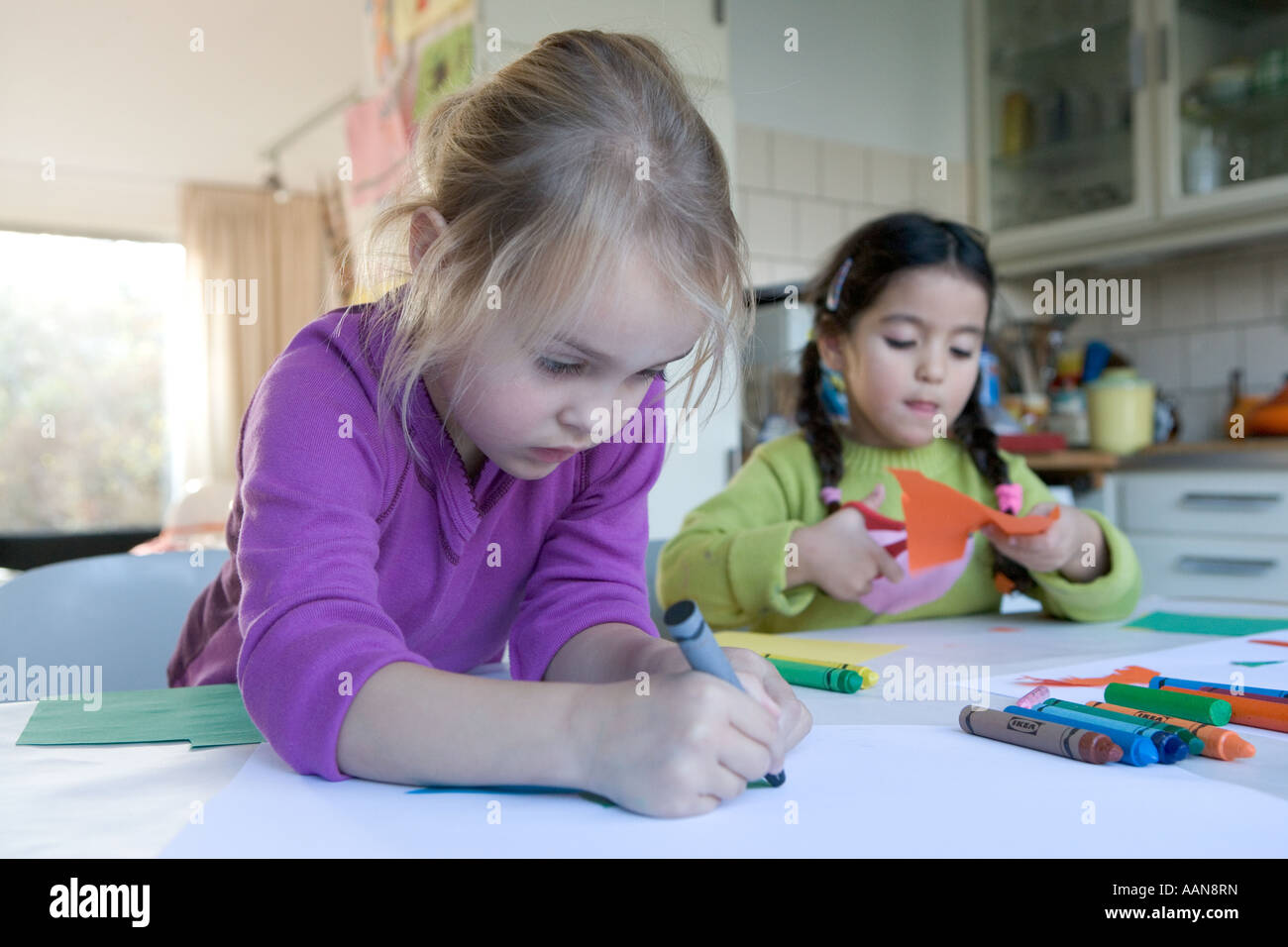Two little girls are drawing and cutting Stock Photo