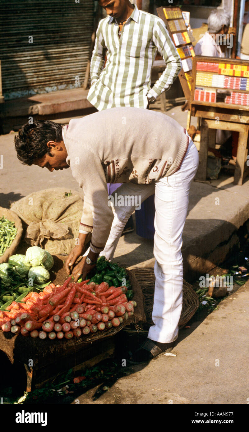 Man selling carrots in market in the streets around the Jama Masjid mosque in Old Delhi INDIA Stock Photo