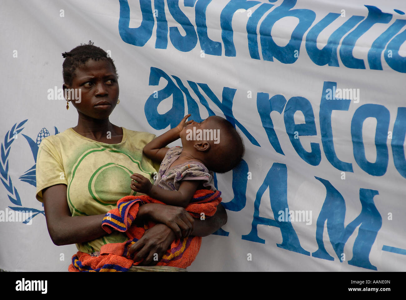 Displaced Congolese woman holds her child as she waits food distribution carried out by World Food Programme WFP in North Kivu DR Congo Africa Stock Photo