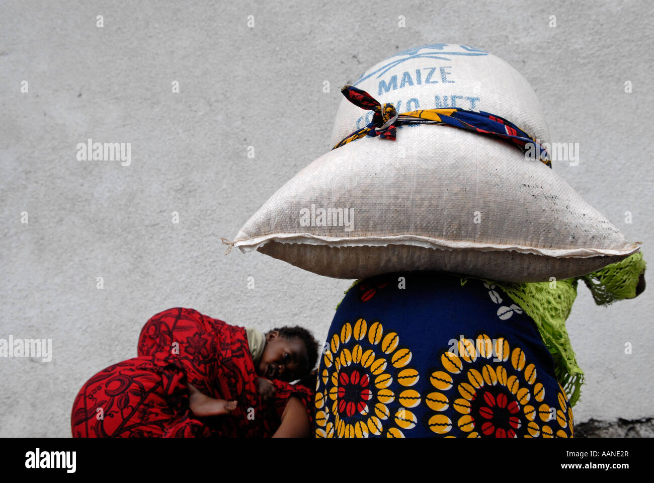 An Internally displaced woman carries large sack of maize during UN World Food Programme WFP distribution in North Kivu, Congo DR Africa Stock Photo