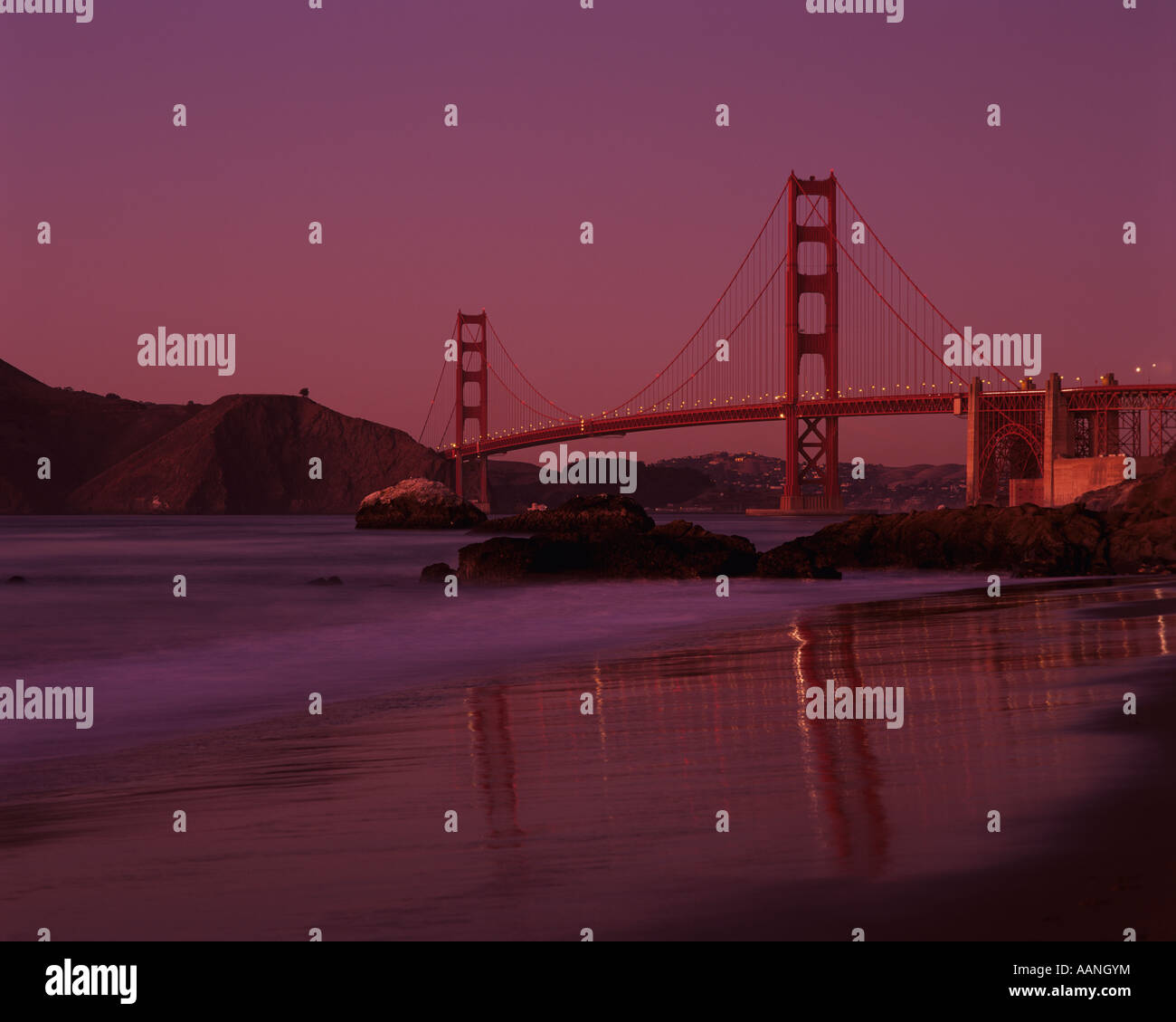 Golden Gate Bridge at sunset with warm light from Baker Beach San