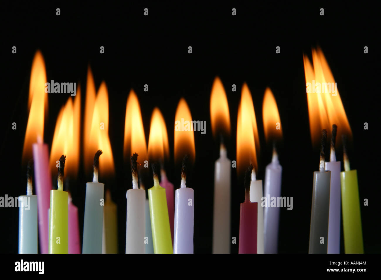 multiple lit birthday candles against black background Stock Photo Alamy