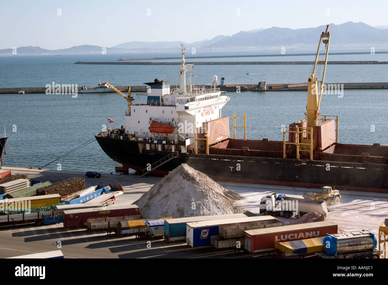 Shipment of salt at Cagliari Dockside, Sardinia, Cagliari Port Sardinia truck lorry ship shipping hold container transport Stock Photo