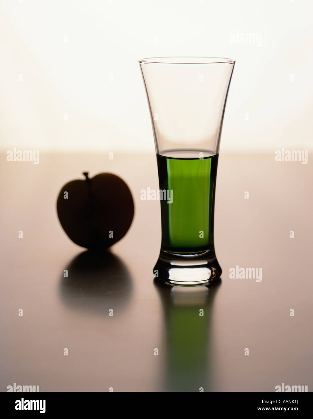 Glass of green drink with apple on plain background Stock Photo