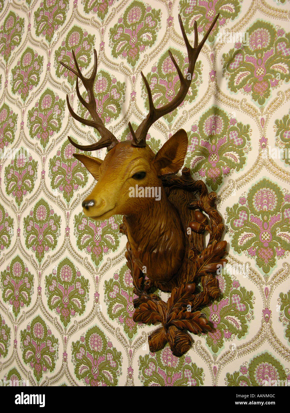 Plastic deer head on an old-fashioned wallpaper Stock Photo - Alamy