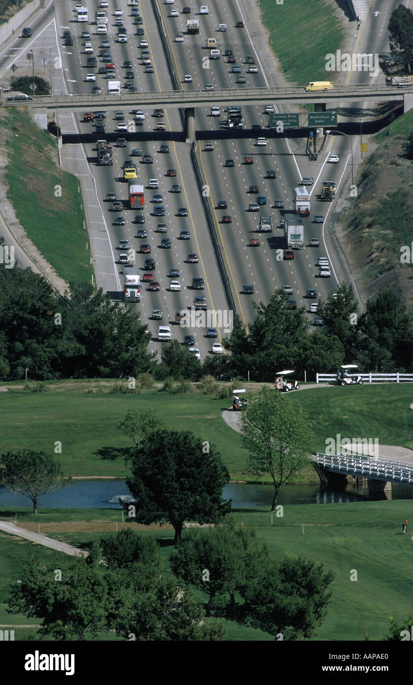 Multilane freeway seemingly disappearing below a quiet golf course in Southern California Stock Photo