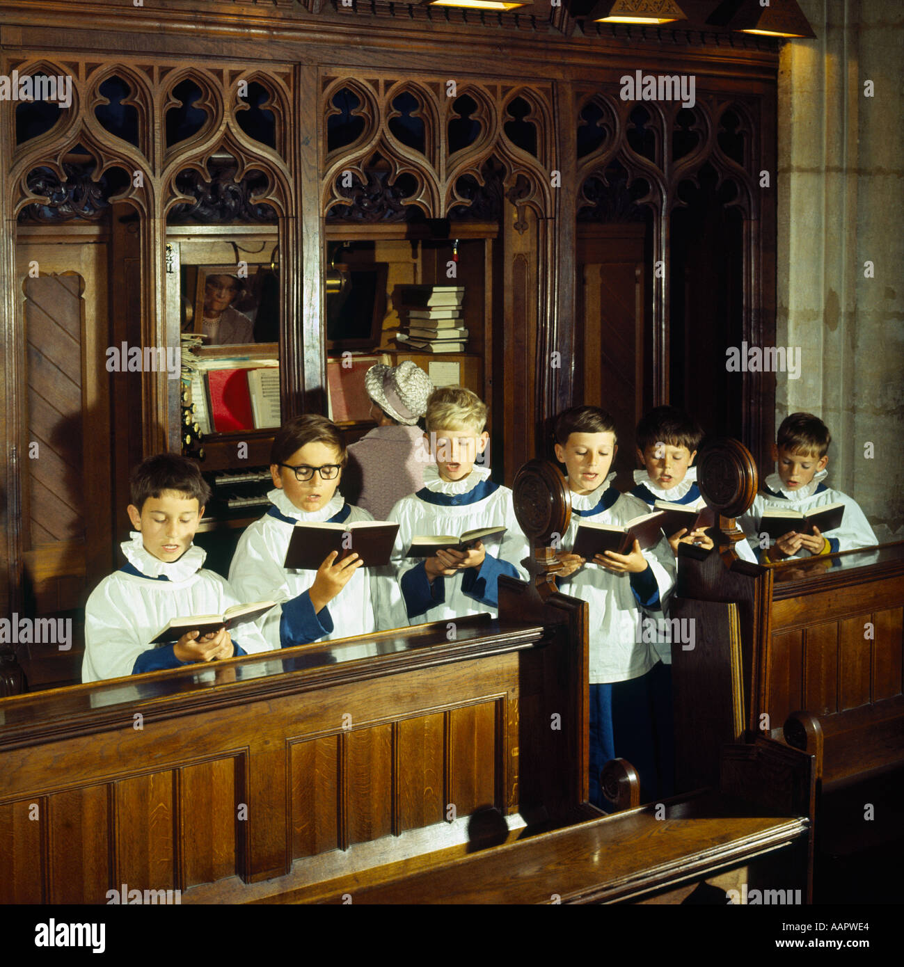 Group of six Choirboys singing with lady Church organist accompanying on organ in the background Somerset England Stock Photo