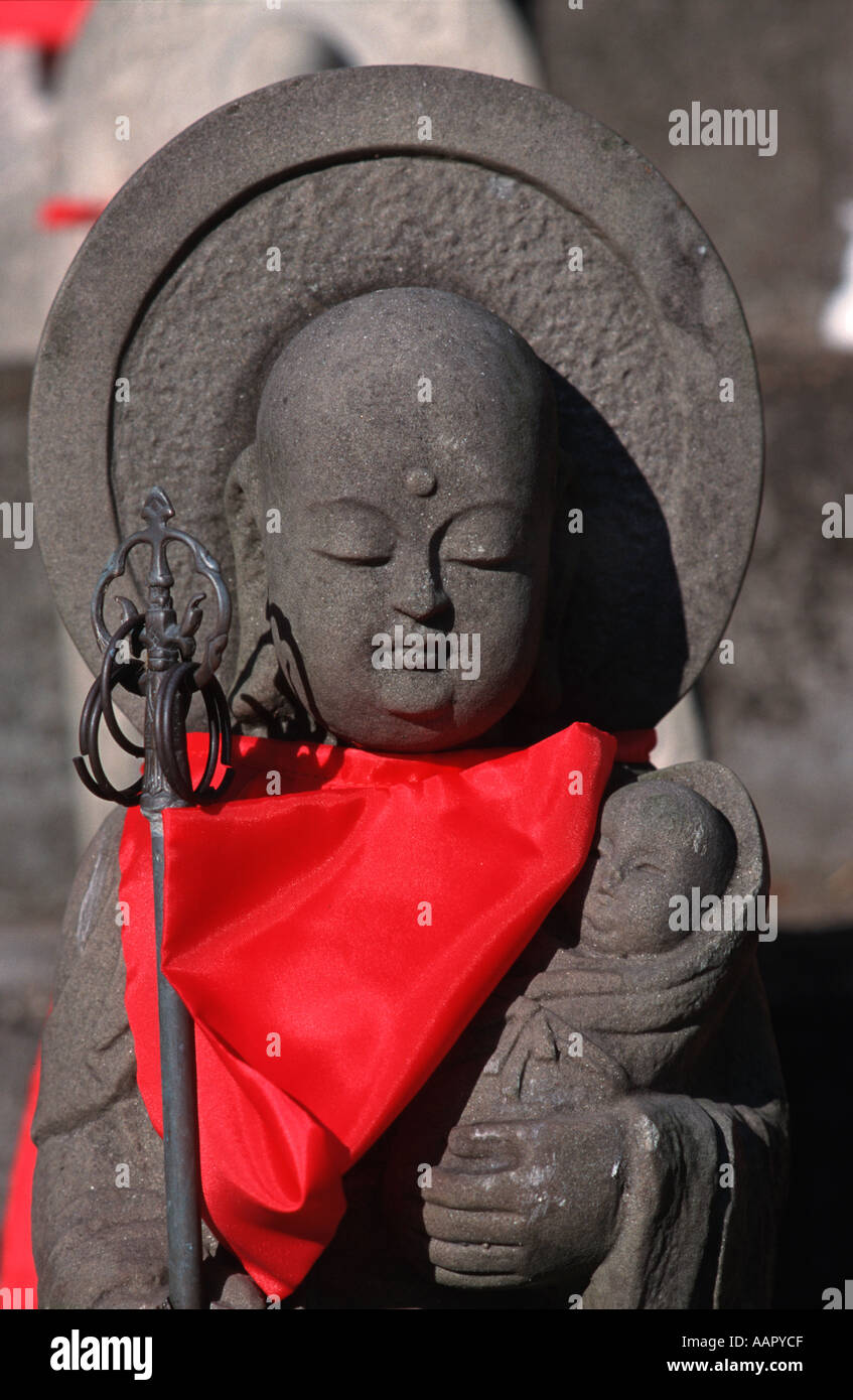 Stone carved Misu Jizo statues with red bib and holding a baby child Taima Nara prefecture Japan