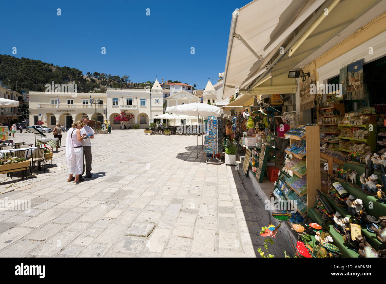 Couple with Guidebook outside shop in St Mark's Square (Aghios Markou Sq), Zakynthos Town, Zakynthos, Ionian Islands, Greece Stock Photo