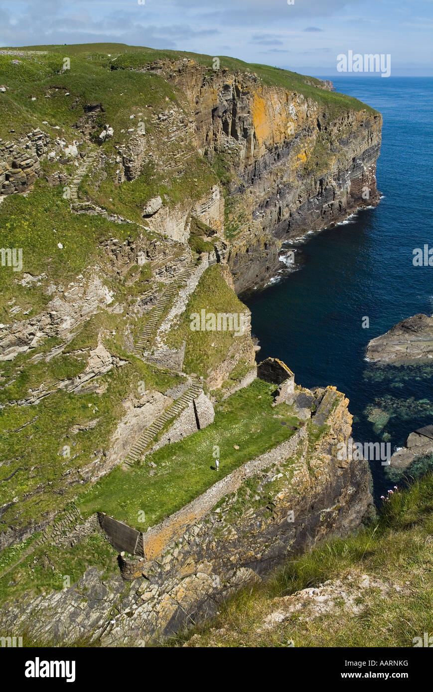 dh  WHALIGOE CAITHNESS Steep stone steps to cove harbour carved out of seacliff and tourist Stock Photo