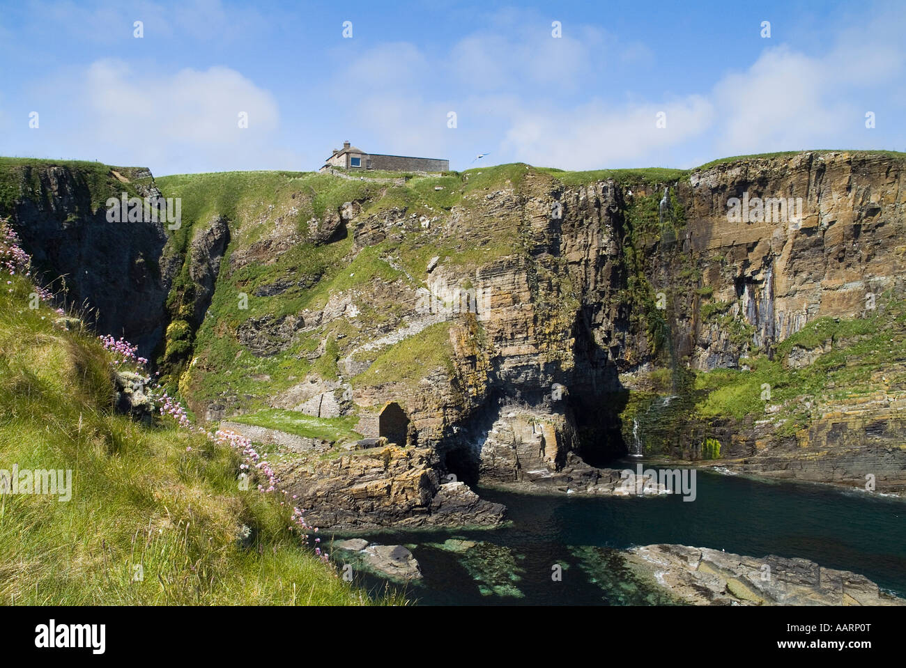dh  WHALIGOE CAITHNESS Steep stone steps to cove harbour carved out of seacliff and house top Stock Photo